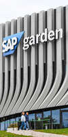 09.10.2026, München, Deutschland. PENNY DEL, Deutsche Eishockey Liga, Saison 2026/27, 7. Spieltag: EHC Red Bull München gegen ERC Ingolstadt im SAP Garden in München. Außenansicht des SAP Garden im Münchner Olympiapark mit großem SAP Garden-Schriftzug an der Fassade. Zwei Personen gehen am Eingang vorbei.